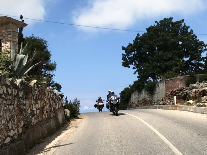 Motorradtour Gruppe fährt in Griechenland durch Gartenlandschaft
